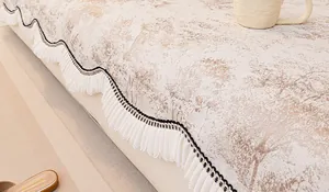 Détail de la housse de canapé en chenille avec motifs de branches et bordure plissée