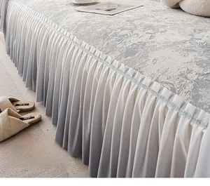 Dettaglio del copridivano grigio con bordi a balze e raffinato motivo jacquard floreale
