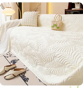 Detail shot of white summer sofa cover featuring embossed feather quilted patterns