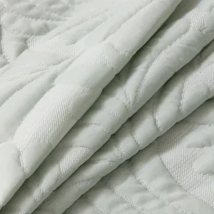Quilted mint green ice silk sofa mat with cooling fabric and textured leaf pattern
