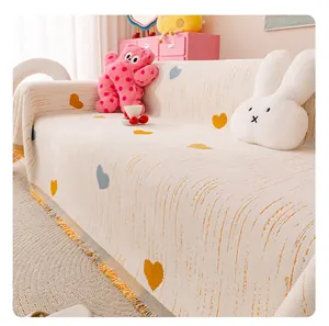 Close-up of chenille sofa cover showing heart pattern and textured knitting with fringe
