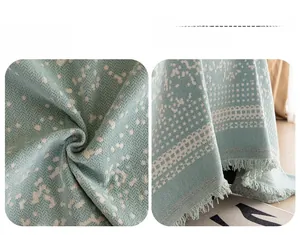 Detail der mintgrünen Chenille-Sofahülle mit Sternenmuster und Fransenquasten