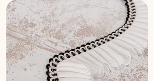 Gros plan d'une housse de canapé en chenille avec bordure en dentelle tissée noir et blanc
