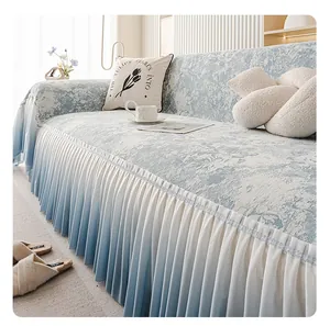 Dettaglio del copridivano floreale azzurro con elegante balza a balze e cuscino coordinato