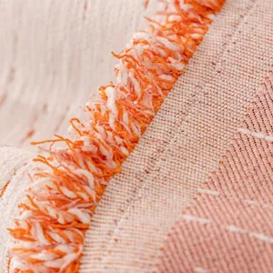 Cream chenille heart pattern sofa cover with orange fringe detail and woven texture