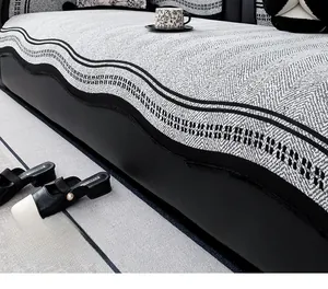 Detail showing grey herringbone chenille sofa cover with black wavy edge on leather couch