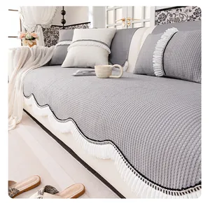 Detalle de funda de sofá gris con textura de gofre y flecos ondulados blancos elegantes
