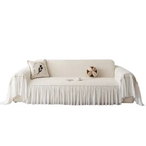 Creamy white chenille sofa cover with diamond patterns and ruffle edges in a clean room