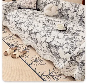 Detail of French vintage floral sofa throw featuring black flower patterns and thick fringe