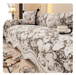 Detailed macro view of vintage floral patterned sofa cover with elegant white fringe edges