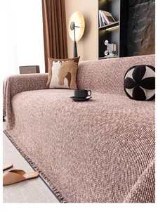 Détail d'une housse de canapé en tricot épais avec franges et texture tissée orange