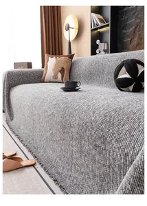 Détail de la housse de canapé en tricot gris avec des franges et texture tissée