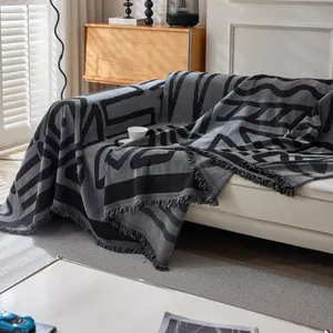 Modern grey geometric jacquard sofa cover with fringe detail for elegant home decor