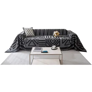 Modern grey bohemian sofa cover with geometric pattern and decorative tassels