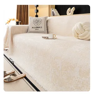 Detail of chenille sofa cover with embossed texture and tassel edges in cream white