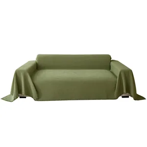 Solid green waffle chenille sofa cover with tassels on a three-seater sofa