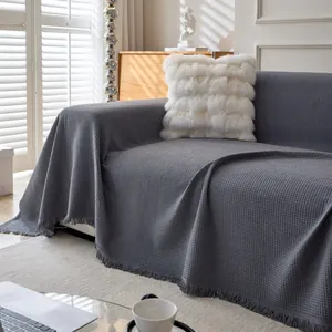Solid color chenille sofa cover in dark grey waffle texture with decorative fringe trim