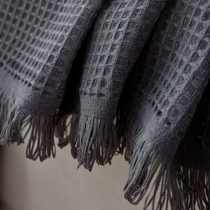 Dark gray chenille sofa cover with waffle texture and elegant tassel fringe detail