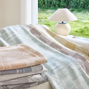Cream colored woven cotton sofa blanket with geometric jacquard pattern for home decor