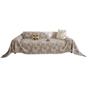 Cream-style geometric patchwork cotton sofa cover with tassels on white background