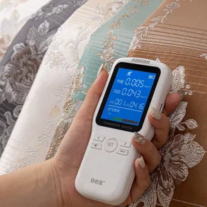 Handheld air quality monitor showing HCHO, TVOC, CO2 and AQI levels on LCD screen