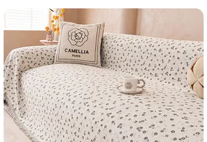 Detail of chenille sofa cover with grey floral pattern, jacquard texture and fringe edges