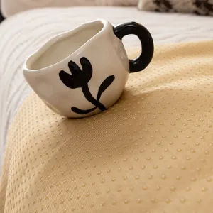 Artistic cream-white ceramic mug with black flower pattern and curved handle