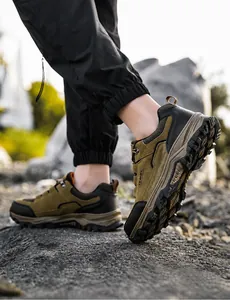Detailaufnahme brauner wasserdichter Wanderschuhe mit rutschfester Gummisohle auf Kies
