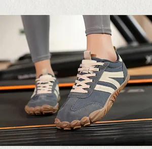 Close-up of gray suede barefoot shoes with gum rubber sole on a gym treadmill