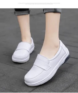 Macro shot of white leather loafers with a visible air cushion for comfort on grey pavement