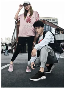 Outdoor shot of lightweight fly-knit mesh sneakers in pink and black for couples