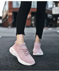 Close-up of pink knit upper and white wavy sole of breathable running shoes
