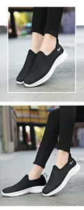 Detail view of breathable black mesh slip-on sneakers with white sport sole and S logo