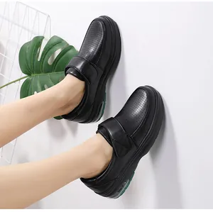 Detail of black wedge nurse shoe with velcro strap, perforated leather and green air cushion