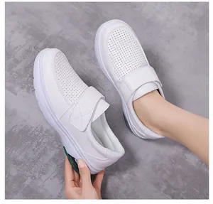 Detail view of white nursing shoes with breathable perforations and velcro strap closure