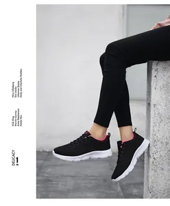 Scarpe da corsa in mesh nero da donna con dettagli rosa indossate da una modella