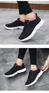 Dettaglio della tomaia in mesh nero traspirante e interno rosa della scarpa sportiva