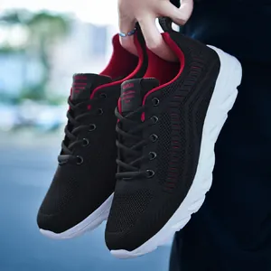 Detail of breathable black knit mesh running shoe with red interior and cushioned white sole