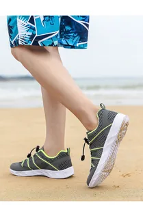 Details grauer Wasserschuhe aus Mesh mit grünen Akzenten am Sandstrand
