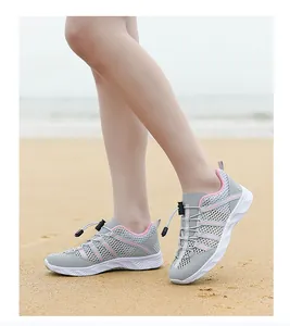 Details von grauen Mesh-Wasserschuhen mit rosa Futter am Strand mit atmungsaktiven Löchern