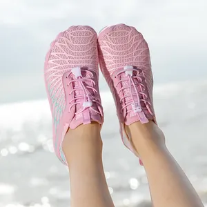 Pink outdoor water shoes with quick-lace system shown on feet at a sunny beach setting