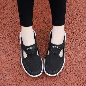 Detail view of breathable black mesh sport sandals with white rubber sole on track