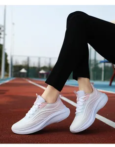 Dettaglio delle scarpe da corsa da donna in mesh sfumato su pista all'aperto