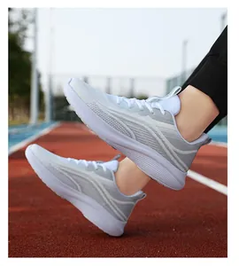 Dettaglio di scarpe sportive traspiranti in mesh con suola ammortizzata su pista di atletica