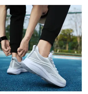 Detailaufnahme grauer Mesh-Sportschuhe mit weißen Schnürsenkeln auf einer Outdoor-Bahn