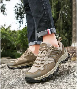 Detail view of brown breathable mesh hiking shoes on rocks with non-slip rubber outsole