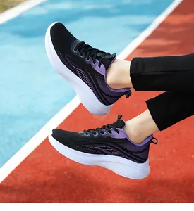 Dettaglio di scarpe da corsa leggere in mesh nero e viola su una pista atletica
