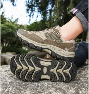 Close-up of khaki mesh hiking shoes with anti-slip rubber soles on outdoor terrain