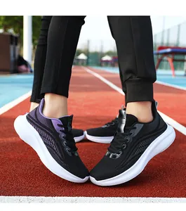 Dettaglio di scarpe da corsa in mesh traspirante su una pista di atletica rossa e blu