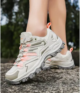 Detail of breathable mesh hiking shoes with anti-slip thick sole on a rocky outdoor surface